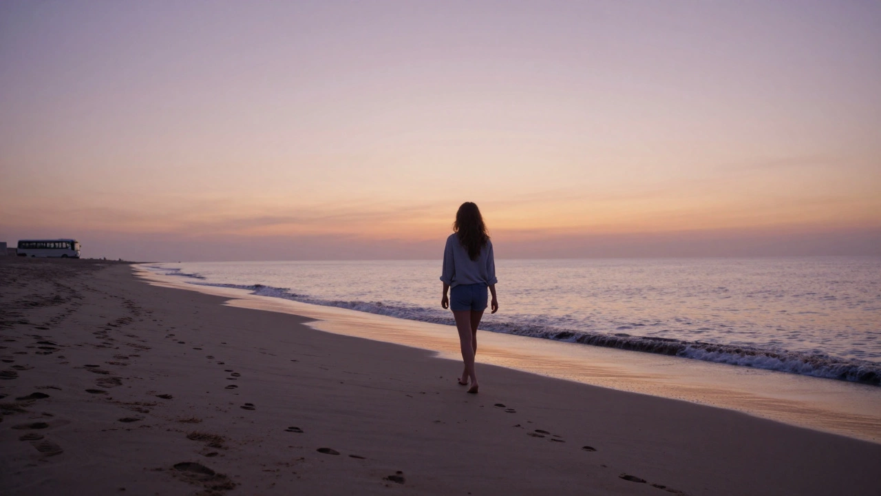 A woman walks barefoot on a quiet beach at sunset, no phone, no belongings, footprints fading behind her.